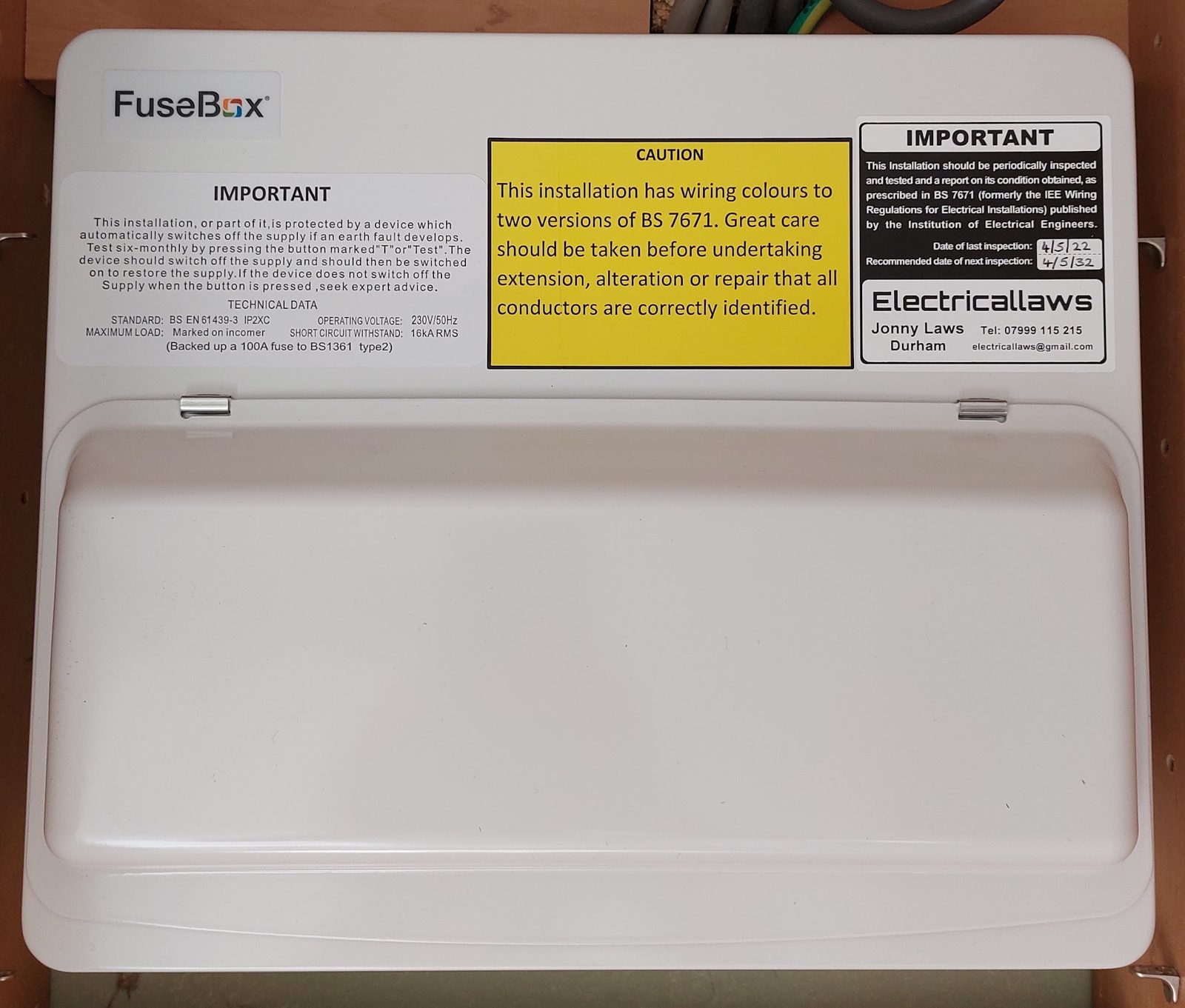 A FuseBox consumer unit with caution and inspection labels, including the Electricallaws label