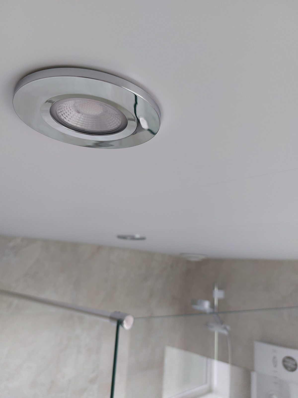 A chrome downlight in a bathroom ceiling